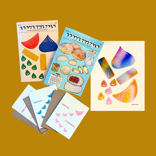 Issue 1 and Issue 2 of the Above the Fold zine with three notecards and the gradient print